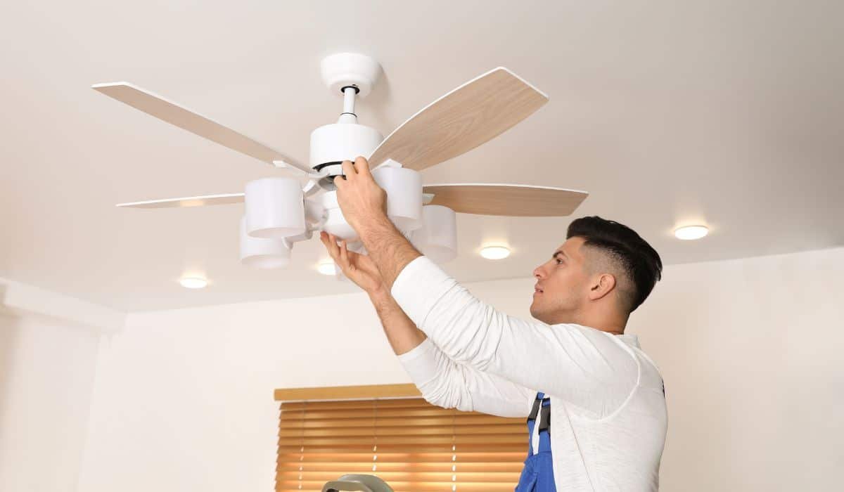 una persona che sta montando dei ventilatori da soffitto